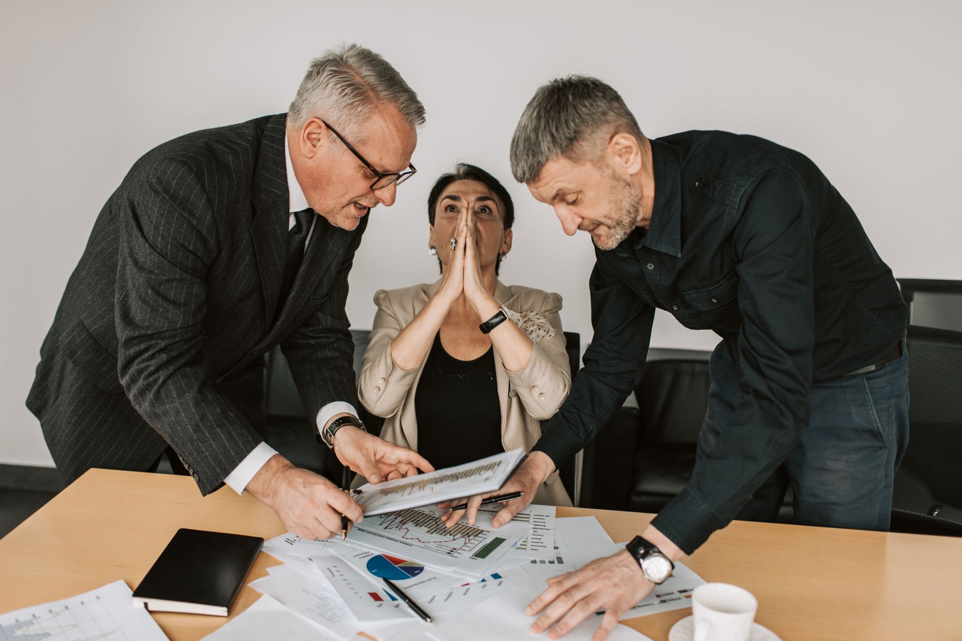 A group of diverse professionals engaged in a focused discussion in a modern office setting.