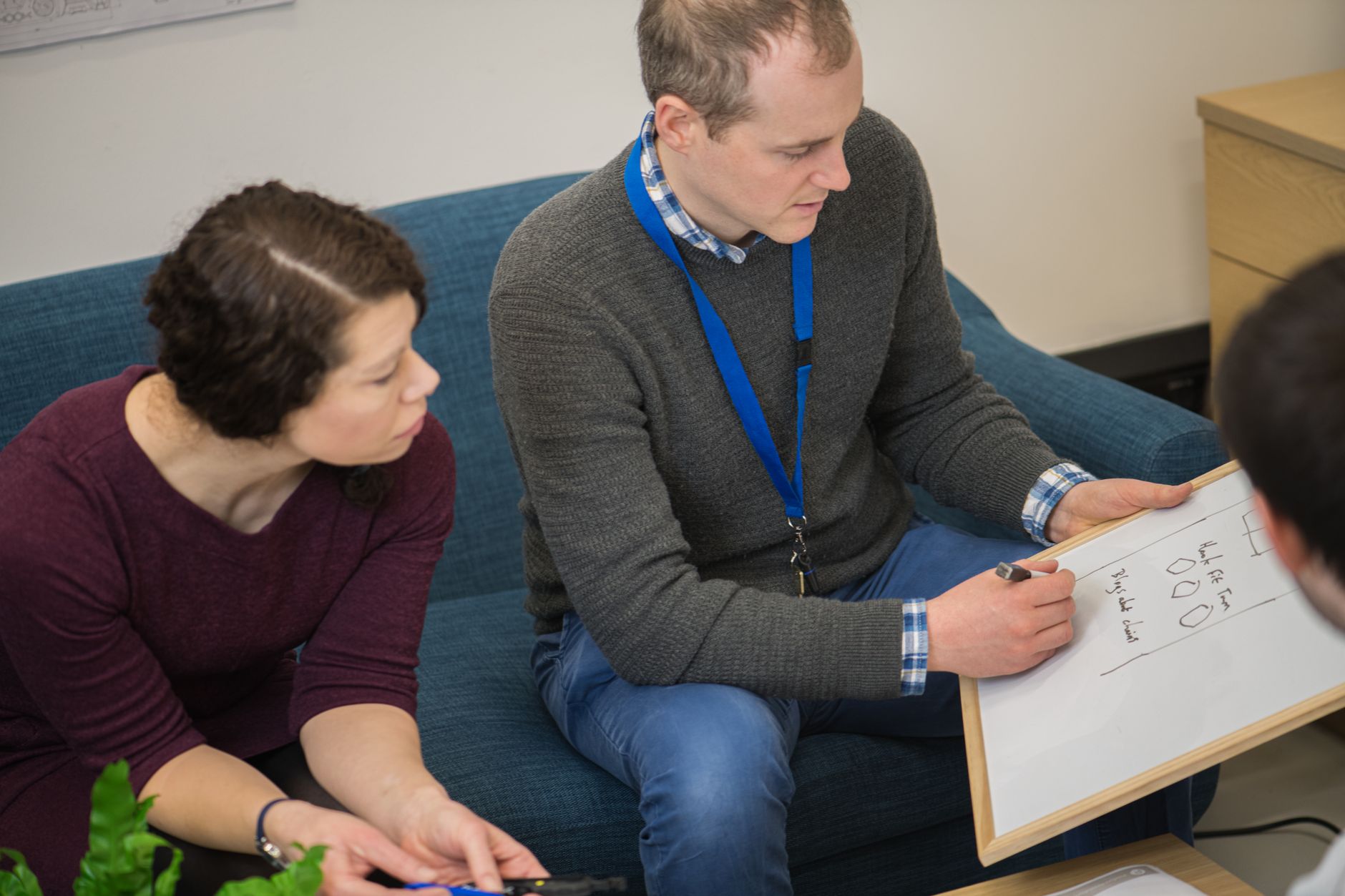 Collaborative workplace planning session with colleagues using a whiteboard.