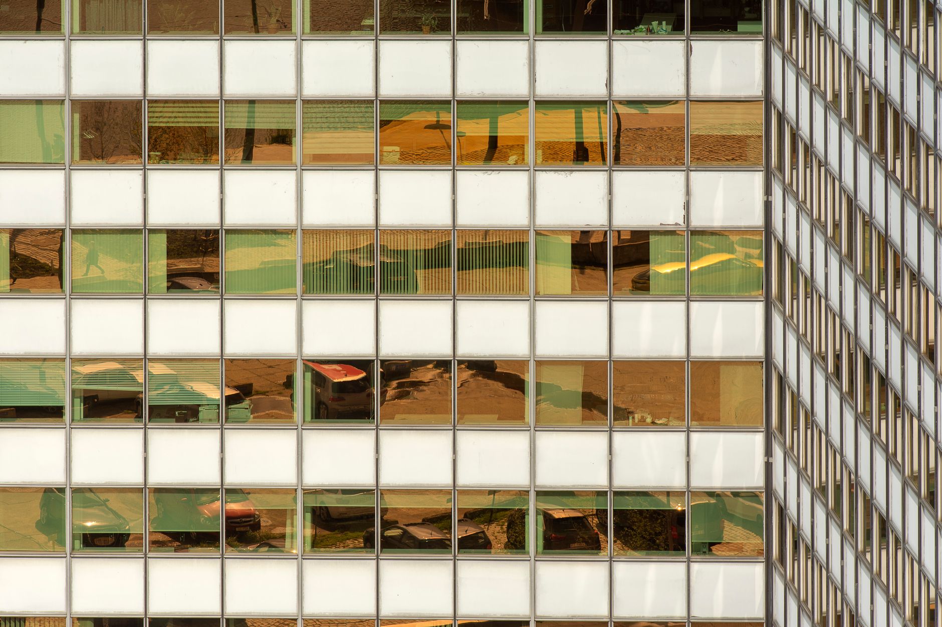 A modern office building facade with reflections of the urban environment in the windows.